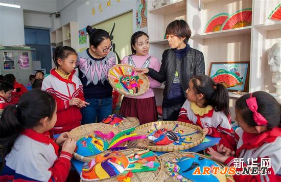 12月17日，内蒙古呼和浩特市玉泉区通顺街小学的老师和喜欢面具艺术的孩子一起交流面具绘制的技艺。